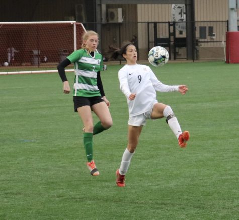 Maddie Massie settles a high pass in the March 17 match with John Carroll. (photo by Russell Dearing)