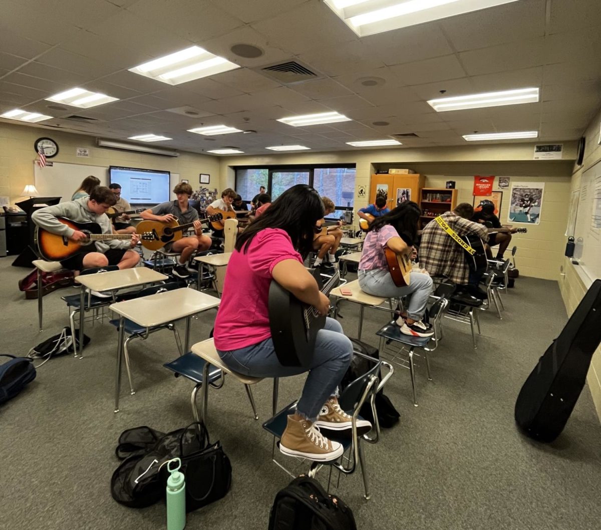 Students+in+the+first-period+guitar+class+tune+their+instruments+and+strum+as+they+warm+up.+