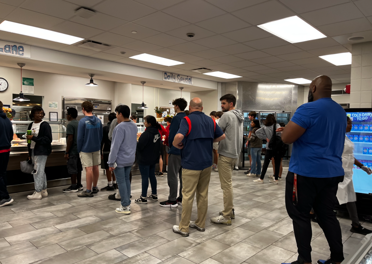 Two lines form full of students waiting for the Thanksgiving meal.