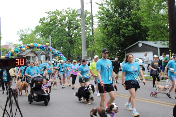 Participants in Mutt Strut 5k making their way past the starting line with their furry friends.