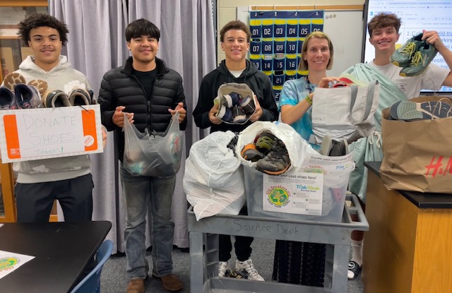 Kelly Roth and several of her students display Homewood's shoe donations. The shoes will travel to Trak Shak and then be shipped to Atlanta.