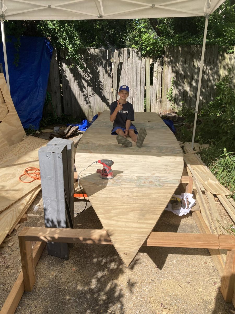 Patrick Ingram sits on his boat's external structure at his at-home worksite. He spent the majority of his summer making calculations and cuts to build the structure. 