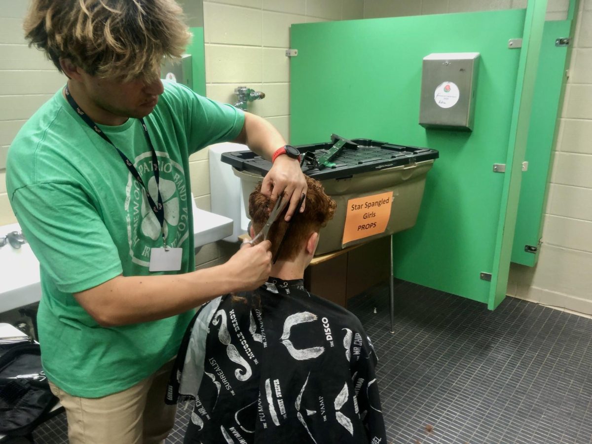 Mr. Mosquera cutting junior Network show choir member Hunter Gonzales's hair. 