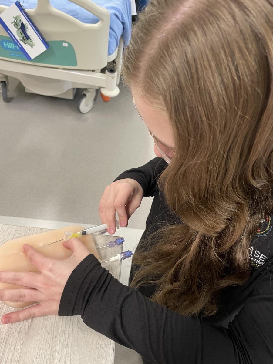 Senior Lola Orcutt practices drawing blood at the RC3 health sciences program.