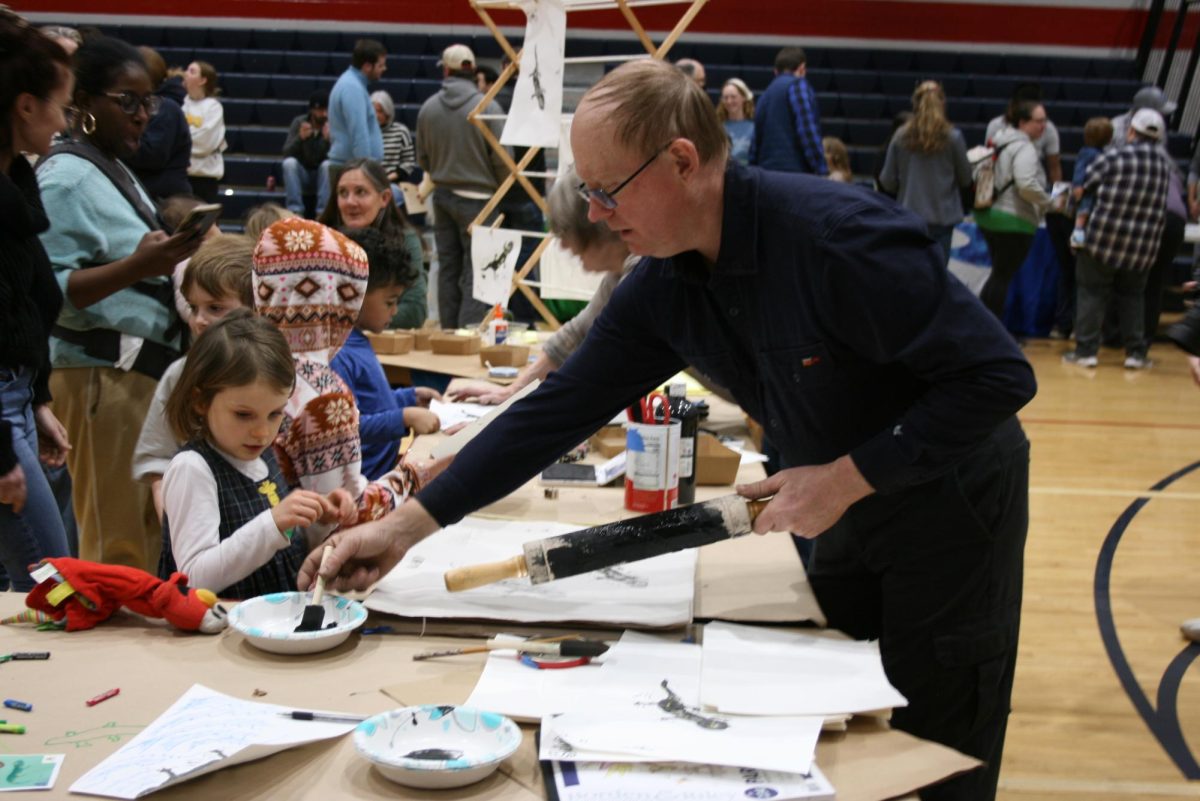 Kids make Salamander prints with ink, rolling pins and the help of volunteers.