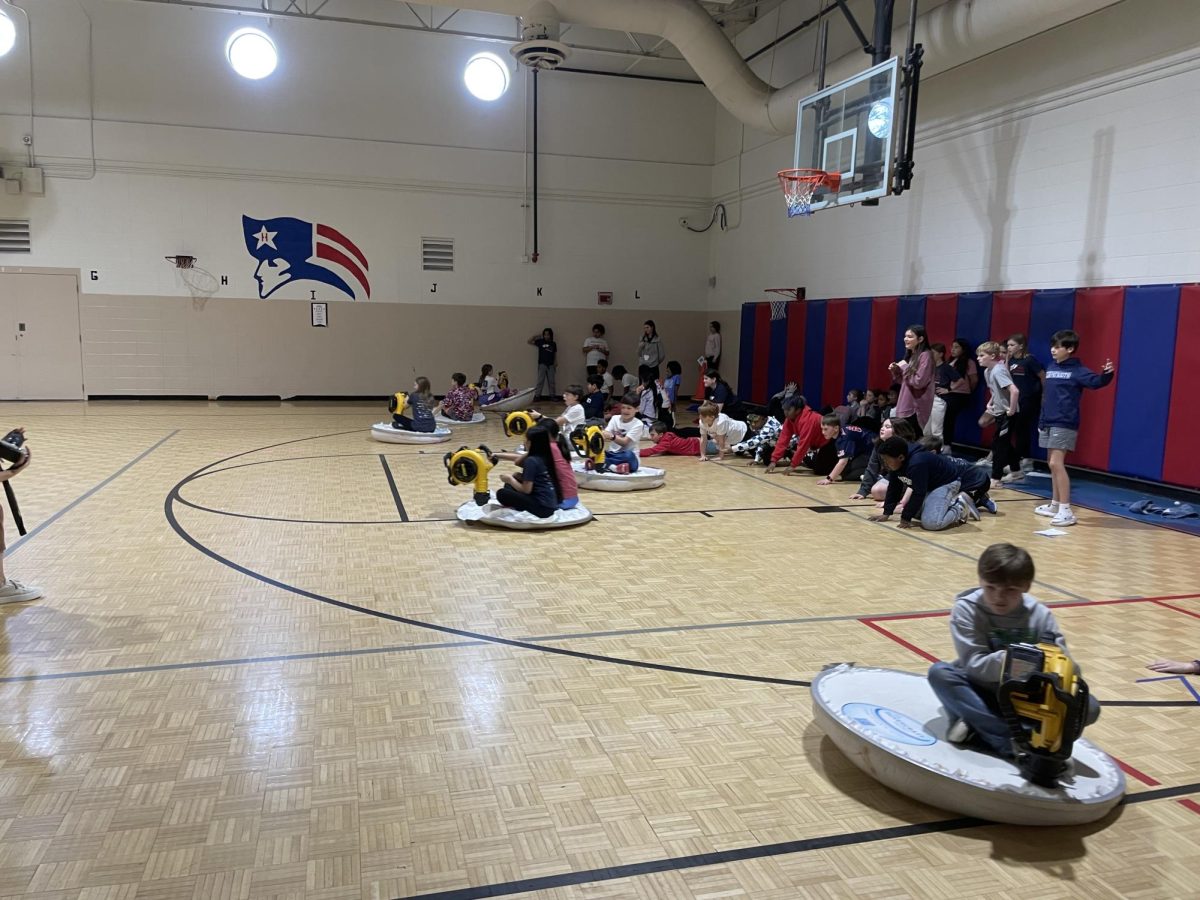 Fifth grade students from Hall-Kent ride the hovercrafts they've assembled.