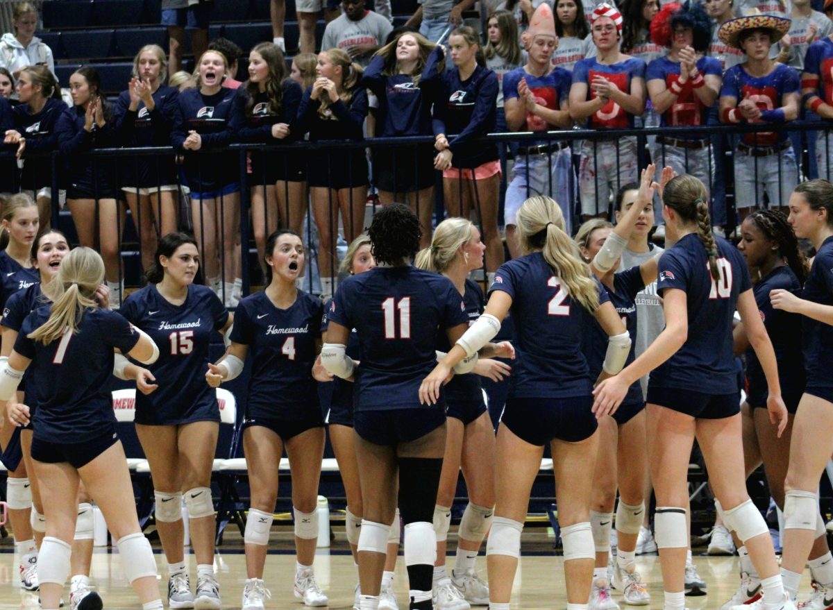 Varsity volleyball players rally around one another during a timeout in the second set. Homewood lost to the Spartans 3-1.