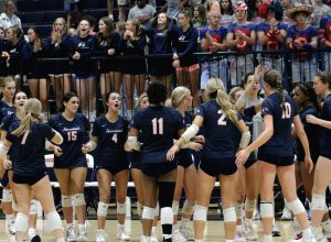 Varsity volleyball players rally around one another during a timeout in the second set. Homewood lost to the Spartans 3-1.