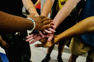 Auditionees place their hands together for good luck before stepping into the spotlight of the Bailey Theater. Thirty-seven students tried out for the 25 roles available in the theater department's production of "Seussical".

