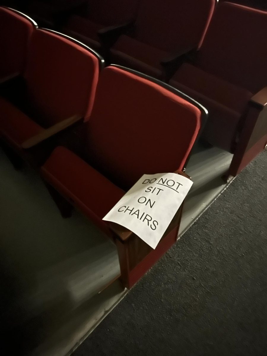 A sign warns people about sitting on a broken auditorium chair. Homewood plans to majorly renovate the auditorium for the first time since 1972.