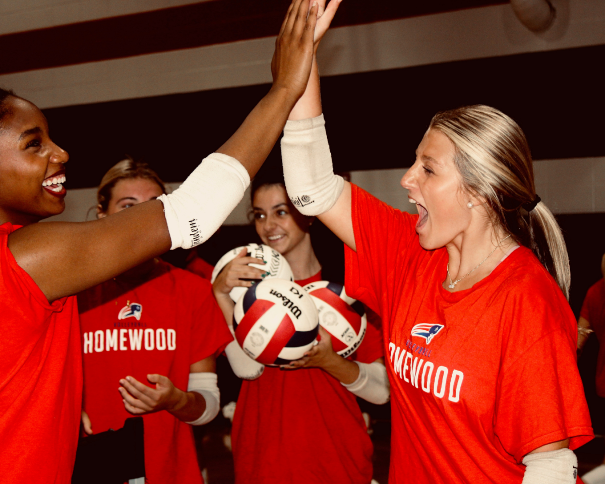 Junior setter Mollie Brown high fives her teammate during practice. The team is currently 8-5 overall.