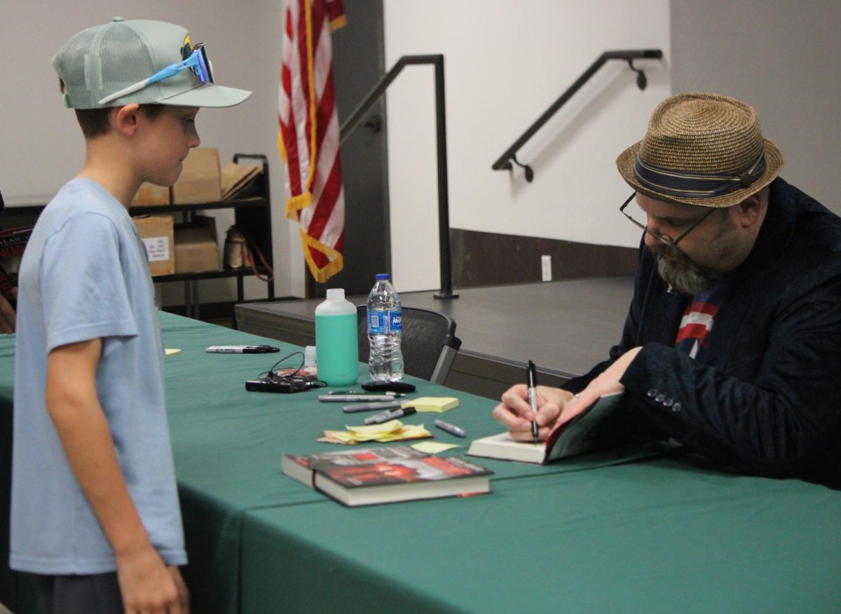 Bestselling author Alan Gratz signs a copy of "Prisoner B-3087" for a young fan. 195 people from the Birmingham metro area attended the book signing event.