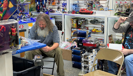Seth Cosby prices collectibles a customer has come in to sell. Seth’s beard and figure represents a sasquatch, explaining the store's name. 
