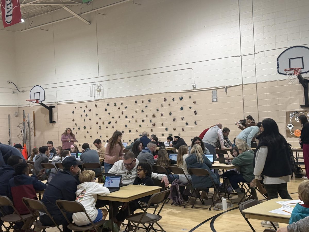 Families gather together for Coding Night in Shades Cahaba's gym. AP Computer Science students volunteered to help debug and troubleshoot tech issues throughout the event.