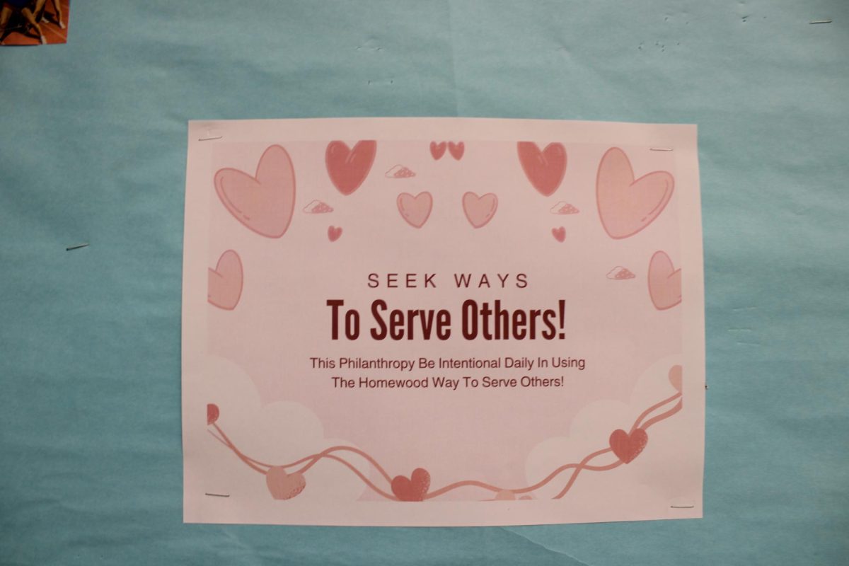 A sign encourages students to seek ways to serve others. The phrase is one of the six attributes of the Homewood Spirit.