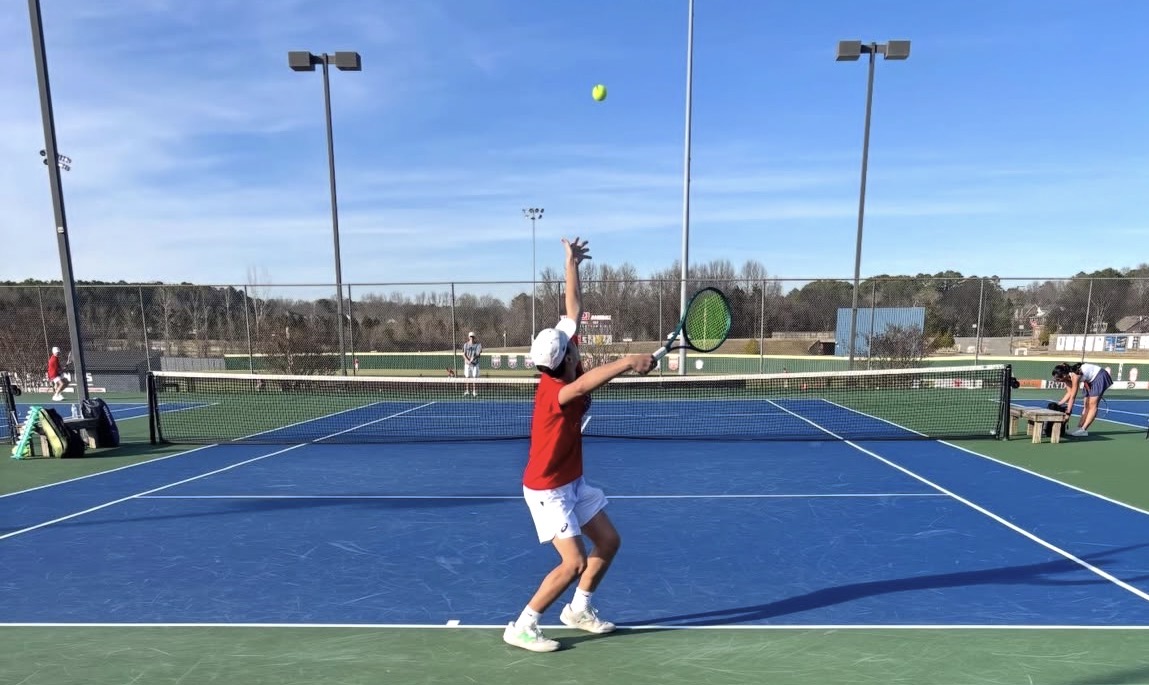 A boys tennis player prepares to serve at the match against Bob Jones. The team cinched a suspenseful win against the Madison school 5-4. Courtesy of Homewood Tennis.