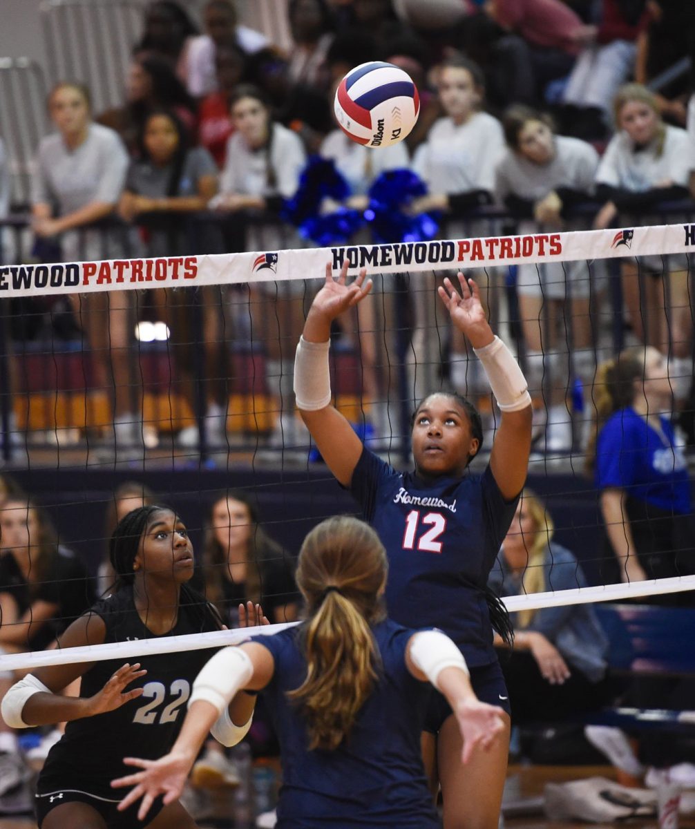Homewood volleyball player Kam Coleman sets during a game. The fight between balancing schoolwork and athletics affects students across disciplines.