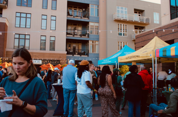 Participants walk and gather to sample beverages and food in SoHo plaza. 35 local vendors provided items representative of their company's brand.